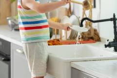 little-boy-washing-plate-in-kitchen-2022-05-19-17-35-24-utc